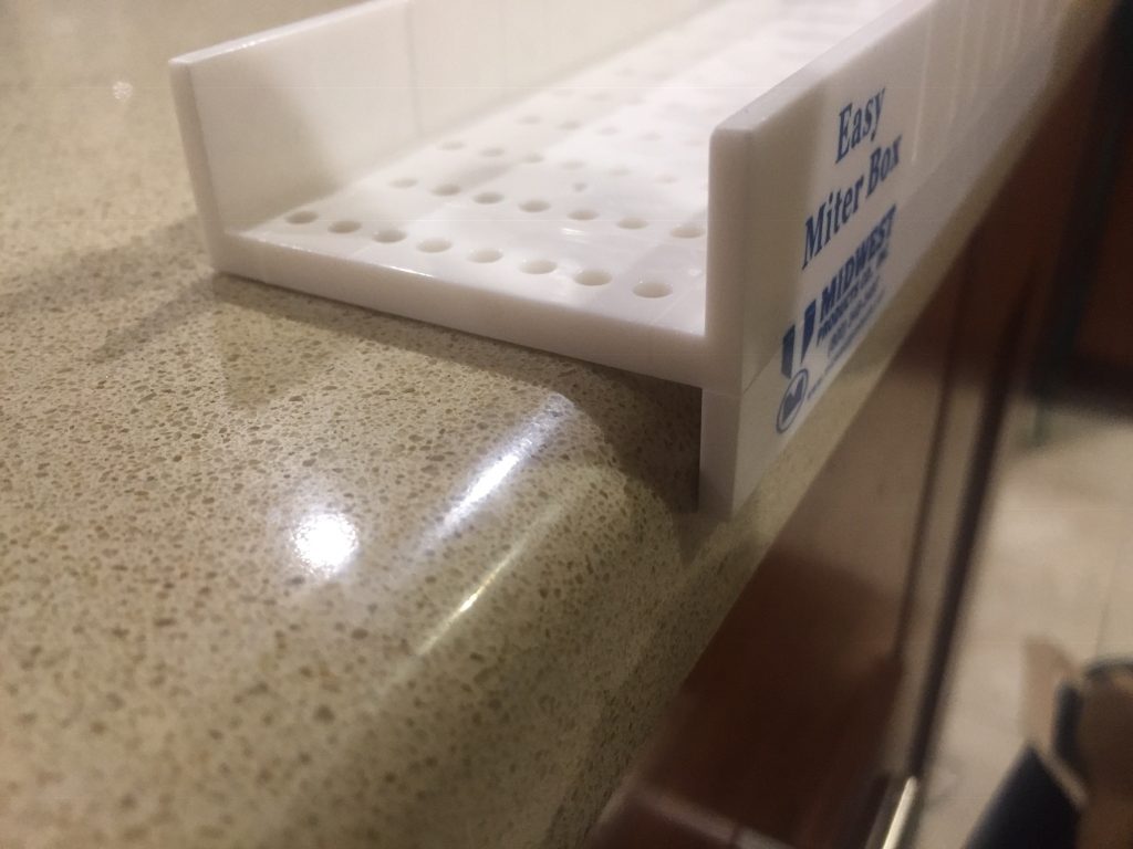 A close up of the miter box hanging over the counter edge.