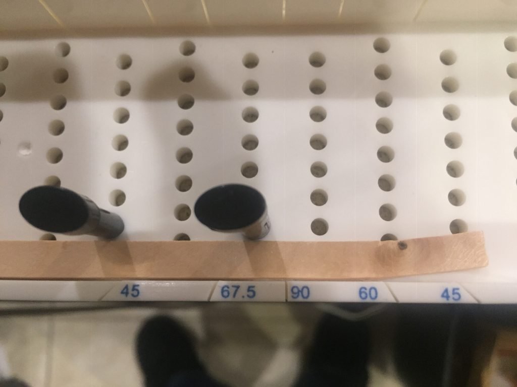 The balsa wood strip anchored in the miter box